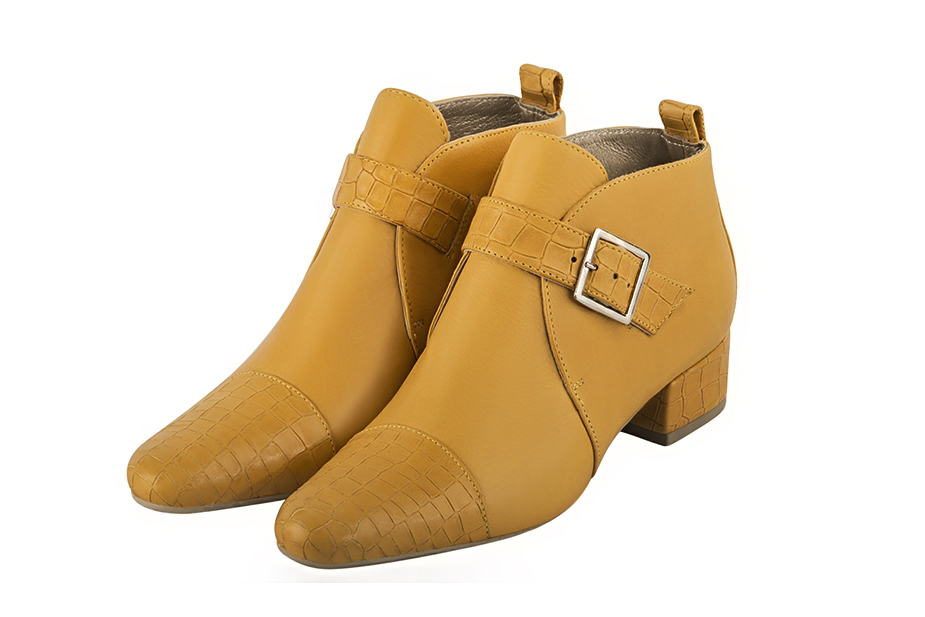 Mustard yellow women's ankle boots with buckles at the front. Round toe. Low block heels. Front view - Florence KOOIJMAN